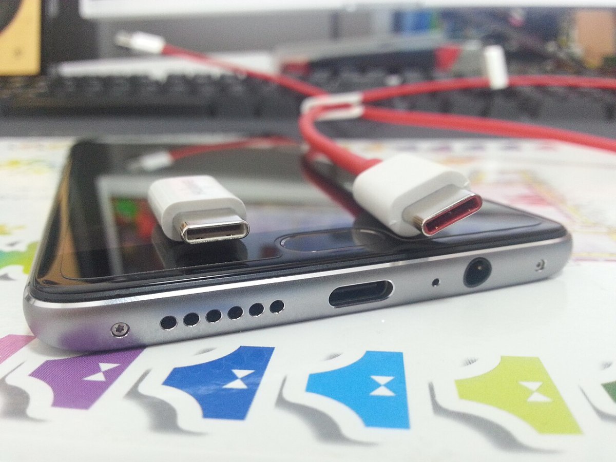 Bir telefonun USB girişi ve yanında şarj kablosu